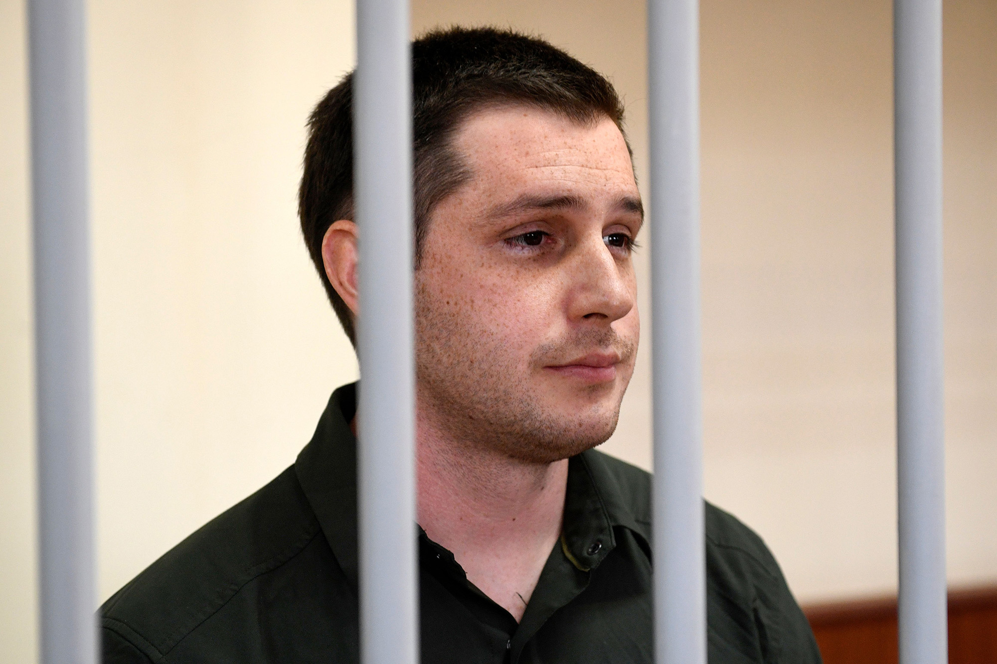 US ex-marine Trevor Reed, charged with attacking police, stands inside a defendants' cage during a court hearing in Moscow, Russia, on March 11, 2020.