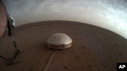 In questa immagine non datata resa disponibile dalla NASA giovedì 22 luglio 2021, le nuvole si spostano sopra il sismometro SEIS coperto dalla cupola del lander InSight su Marte.