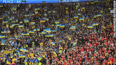 I tifosi ucraini alzano la bandiera del loro paese al Cardiff City Stadium. 