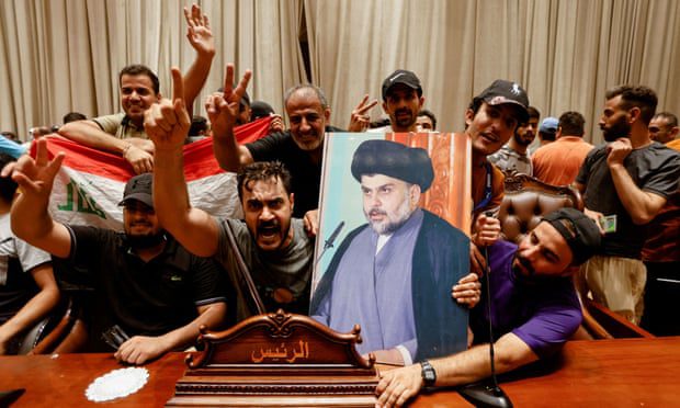 I sostenitori portano una foto del religioso sciita iracheno Muqtada al-Sadr all'interno dell'edificio del parlamento a Baghdad.