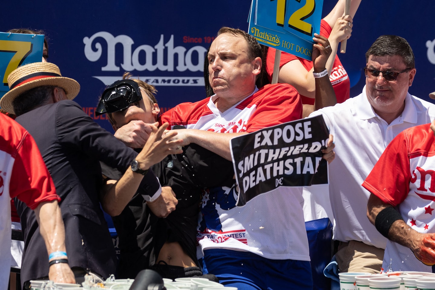 Gli allibratori di Joey Chestnut recuperano i loro soldi dopo una gara di mangiare hot dog agli stand delle proteste