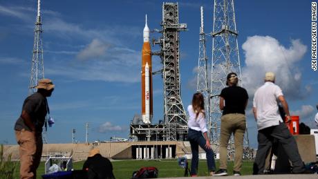Fotografi e giornalisti lavorano lunedì vicino al razzo Artemis 1 della NASA al Kennedy Space Center.  Una serie di problemi ha impedito l'avvio in seguito.