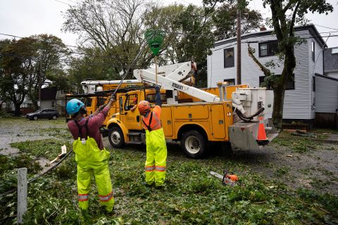 Sabato i lavoratori sollevano i cavi caduti per consentire alle macchine di raggiungere gli alberi caduti ad Halifax.