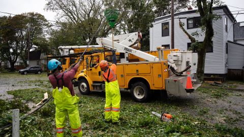 Sabato i lavoratori sollevano un filo tagliato per consentire alle macchine di raggiungere alberi a foglie caduche ad Halifax, in Nuova Scozia.
