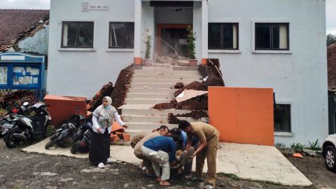 Gli ufficiali municipali di Cianjur evacuano un collega ferito all'indomani del terremoto.