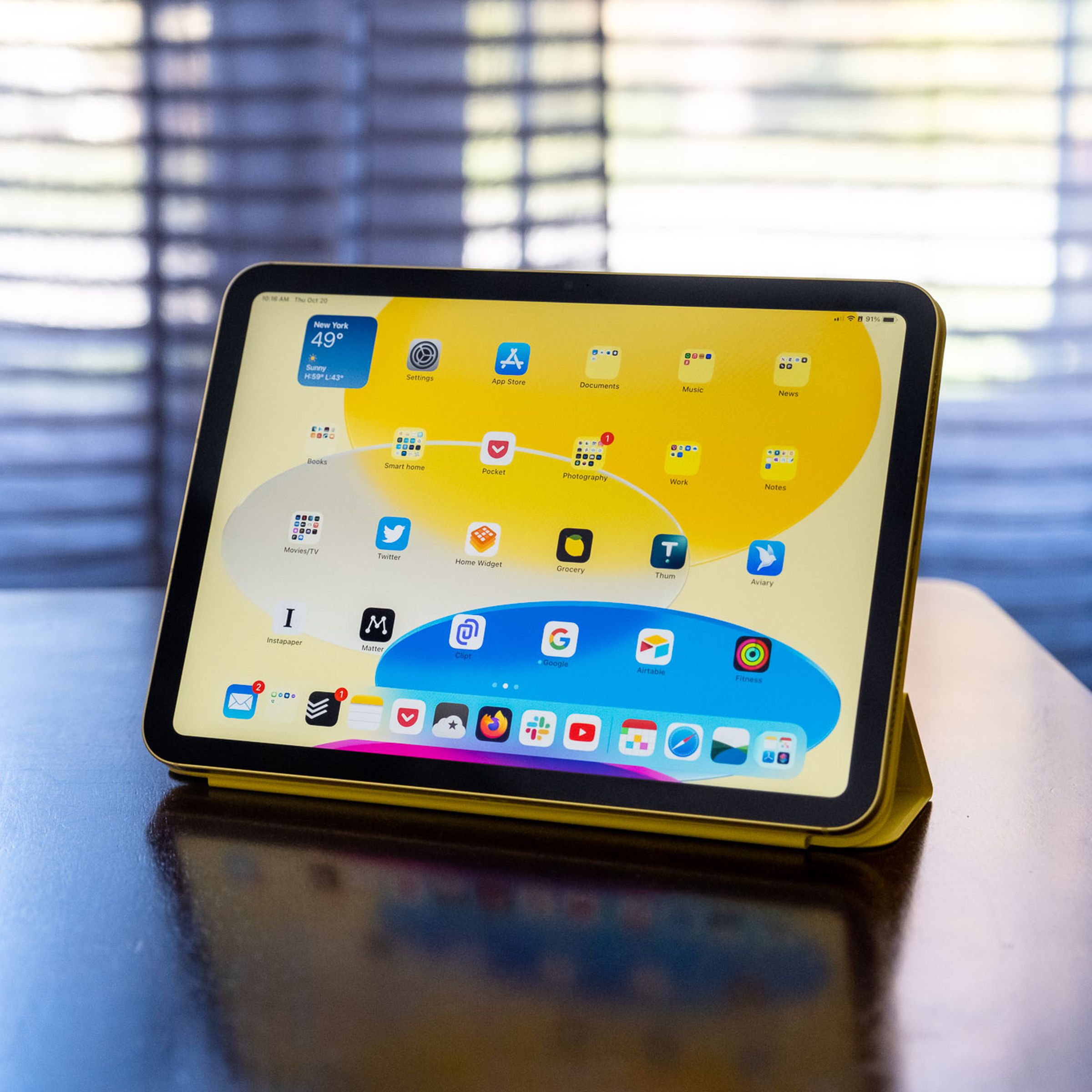 Un iPad di decima generazione in un Apple Smart Folio su un tavolo di legno.