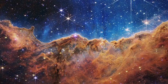 Ciò che assomiglia molto a montagne rocciose in una sera illuminata dalla luna è in realtà il bordo della vicina e giovane regione di formazione stellare NGC 3324 nella Nebulosa Carena.  Scattata alla luce infrarossa dalla Near Infrared Camera (NIRCam) sul telescopio spaziale James Webb della NASA, questa immagine rivela regioni precedentemente oscurate della nascita delle stelle.
